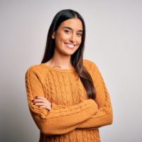 Young beautiful brunette woman wearing casual sweater over isolated white background happy face smiling with crossed arms looking at the camera. Positive person.